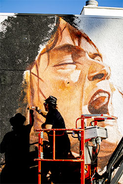 Muralist Robert Vargas works on the Eddie Van Halen mural at Guitar Center Hollywood