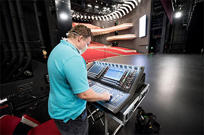 House Tech Matt Buie-Nervik at the DiGiCo SD12 monitor mixing console located at stage left