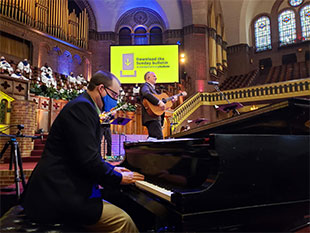 Tim Stafford, pastor of music ministries for The Moody Church, playing guitar while leading praise