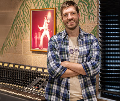 Joe Stolarick standing in front of a console designed by Bruce Jackson, most often associated with Elvis Presley’s tours between 1971–1977